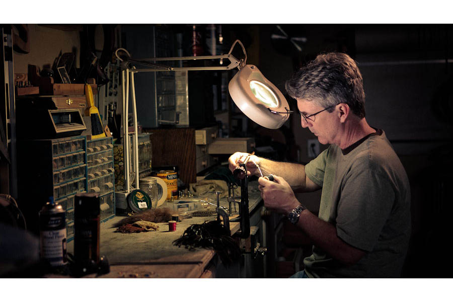 austin portrait photographer portrait of a man working at his bench in his garage tying flies for fishing